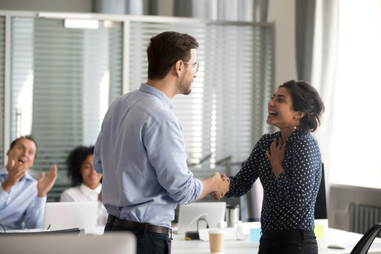 A boss shaking the hand of en employee and showing appreciation